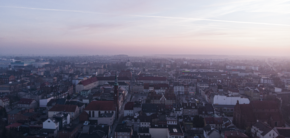 Widok z drona nad miastem Starogard Gdański - dużo domów i bloków na tle nieba